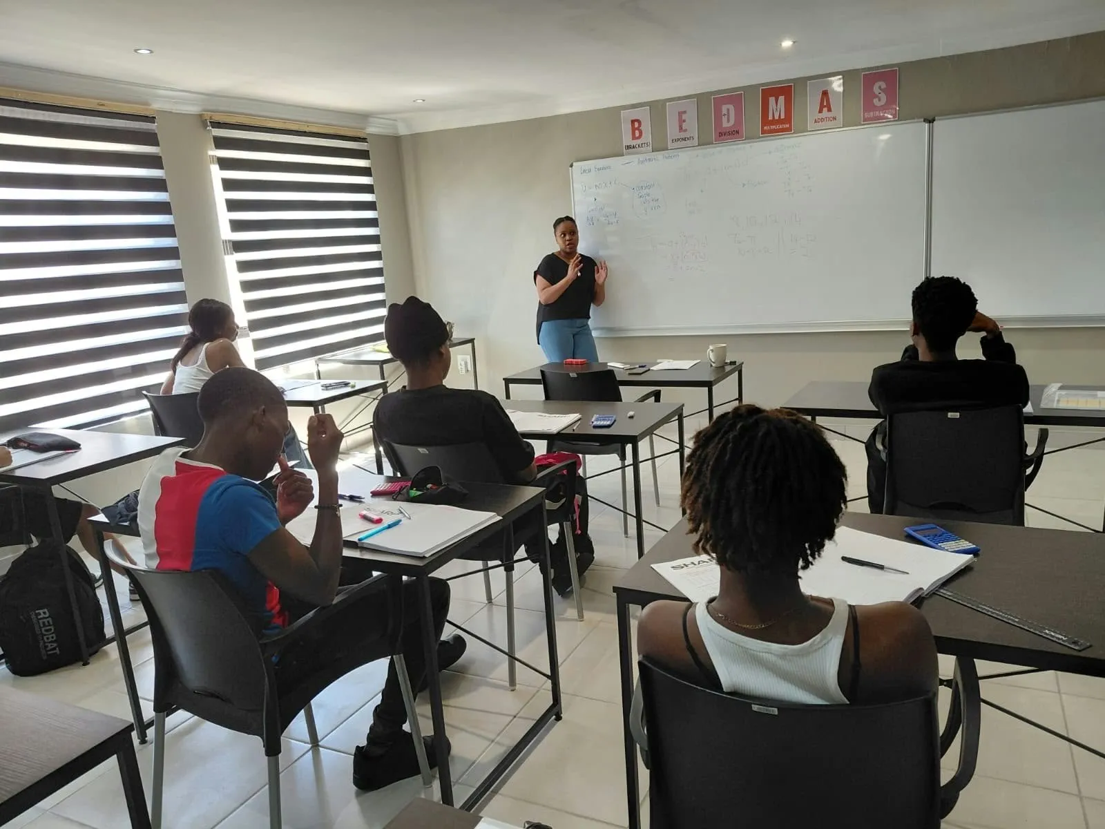 Learners working with pen and paper in a Tally Up classroom