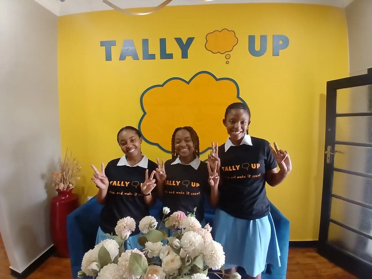 Learners on the blue couch in front of the Tally Up wall