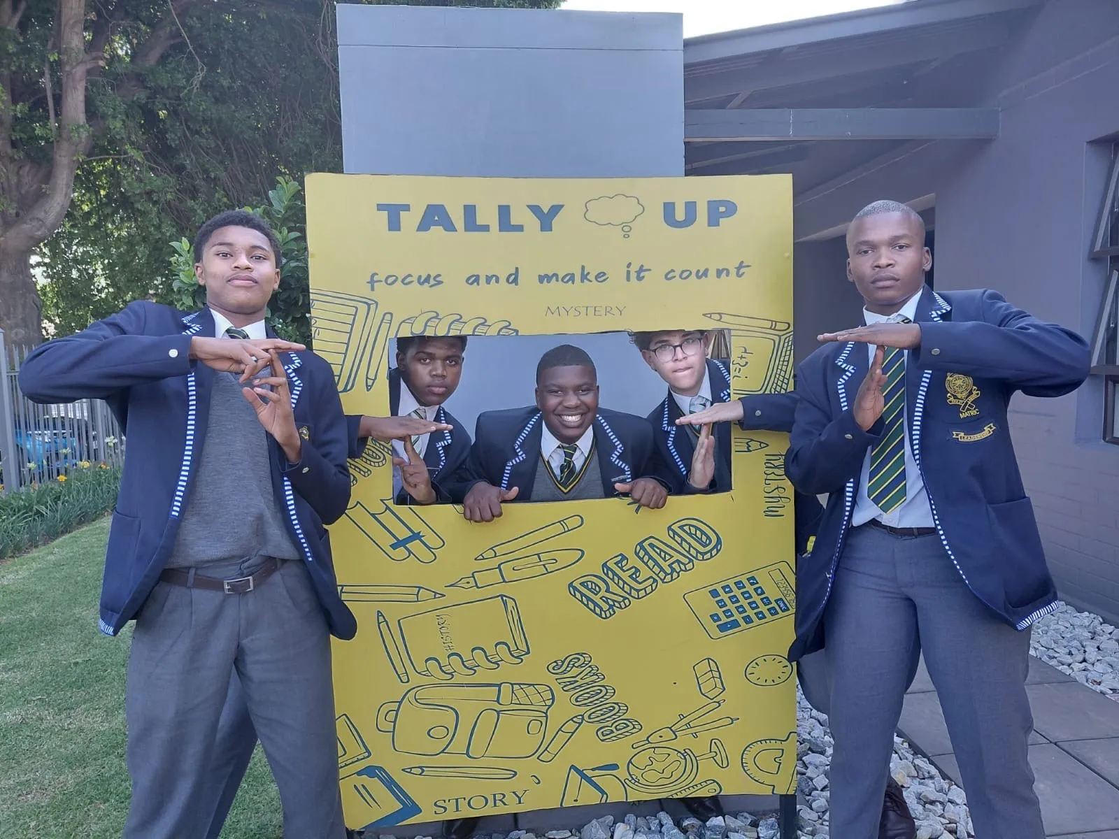Learners in school uniform posing with the Tally Up photo frame