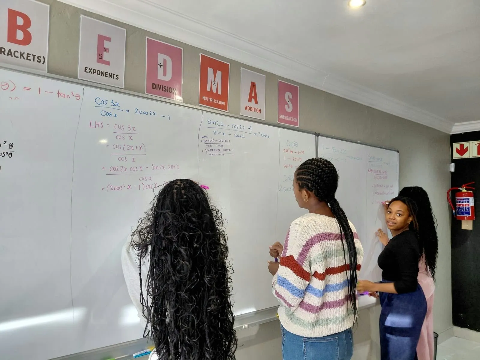 Learners working through BEDMAS problems on the whiteboard
